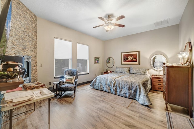 bedroom with ceiling fan, a textured ceiling, and light hardwood / wood-style flooring