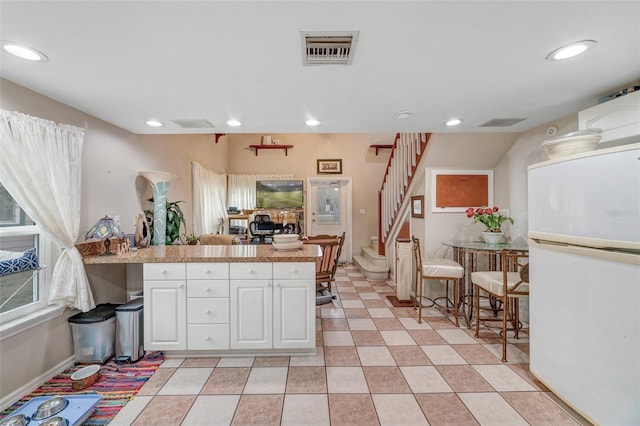 kitchen with white cabinets and white fridge