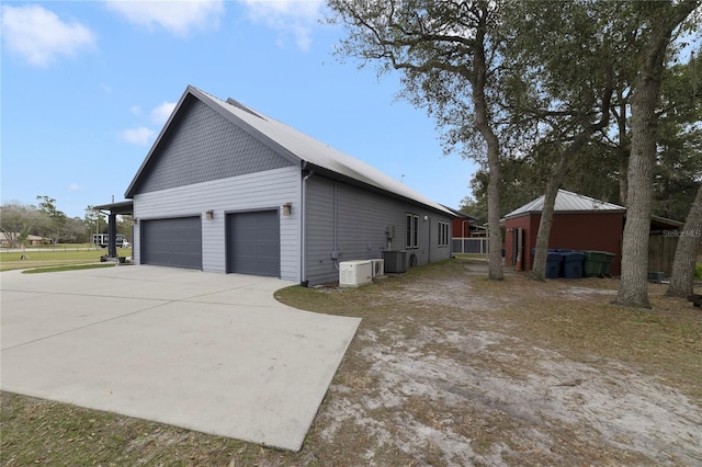 view of side of home with a garage and cooling unit