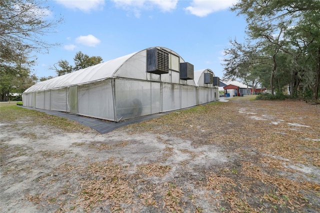 view of property exterior featuring central AC unit and an outdoor structure