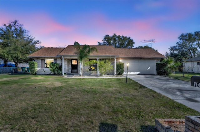 ranch-style home with a garage and a yard