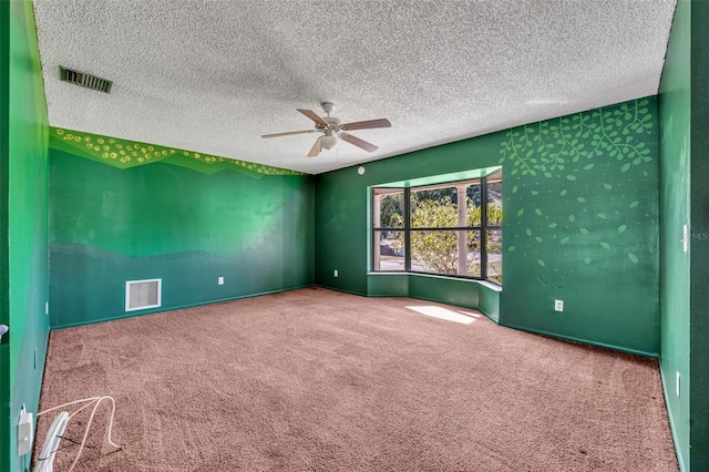 carpeted empty room featuring ceiling fan and a textured ceiling