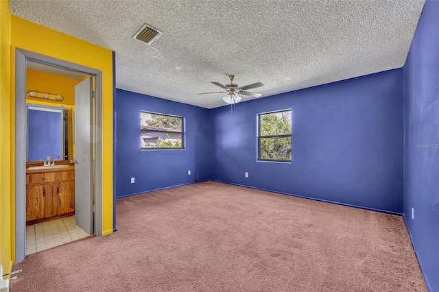 spare room with sink, a healthy amount of sunlight, light colored carpet, and ceiling fan