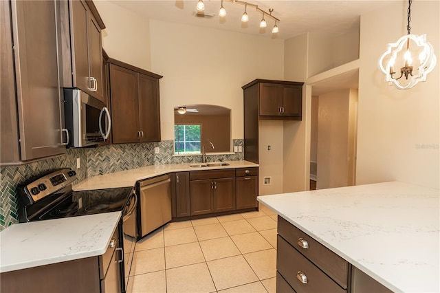 kitchen featuring tasteful backsplash, hanging light fixtures, stainless steel appliances, and sink