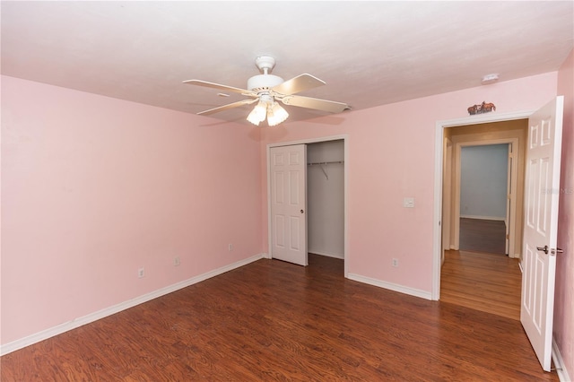 unfurnished bedroom with dark wood-type flooring, ceiling fan, and a closet