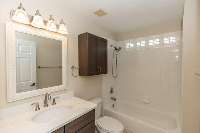 full bathroom with tiled shower / bath combo, vanity, and toilet