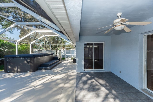 view of patio with a hot tub and glass enclosure