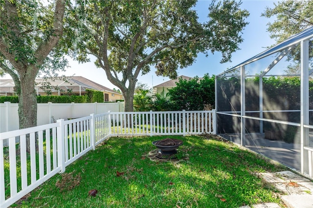 view of yard with a fire pit and a lanai