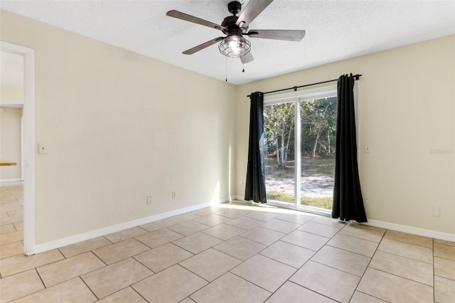 empty room with ceiling fan, a textured ceiling, and light tile patterned floors