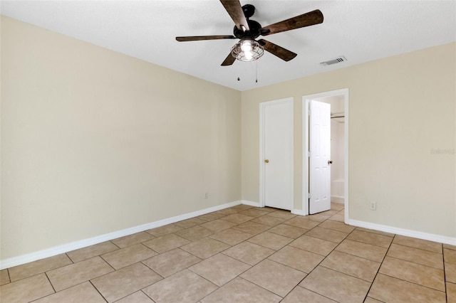 tiled empty room featuring ceiling fan