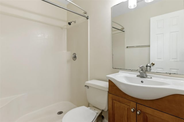 bathroom with vanity, a shower, and toilet