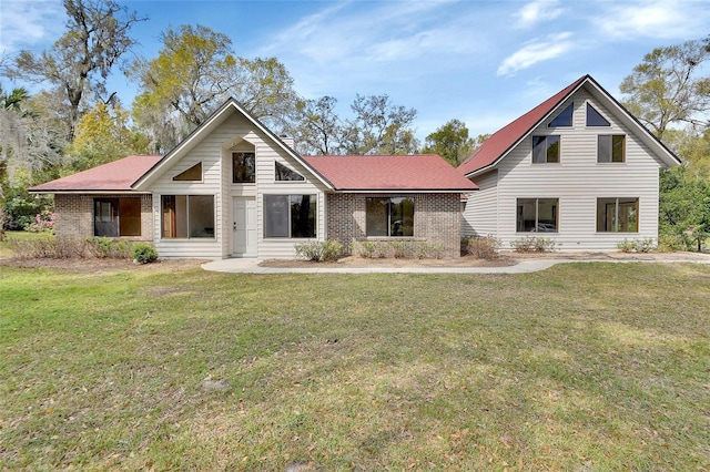 view of front of house featuring brick siding and a front lawn