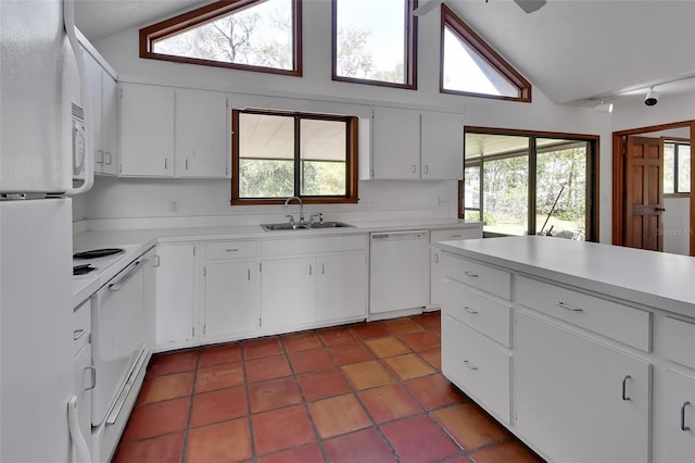 kitchen featuring light countertops, lofted ceiling, plenty of natural light, white appliances, and a sink