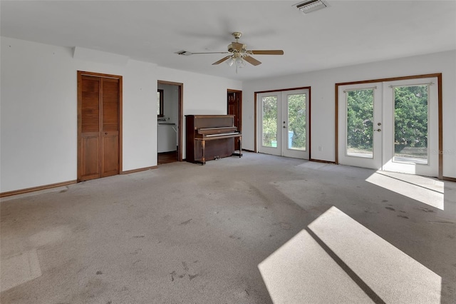 unfurnished living room with baseboards, french doors, visible vents, and light carpet