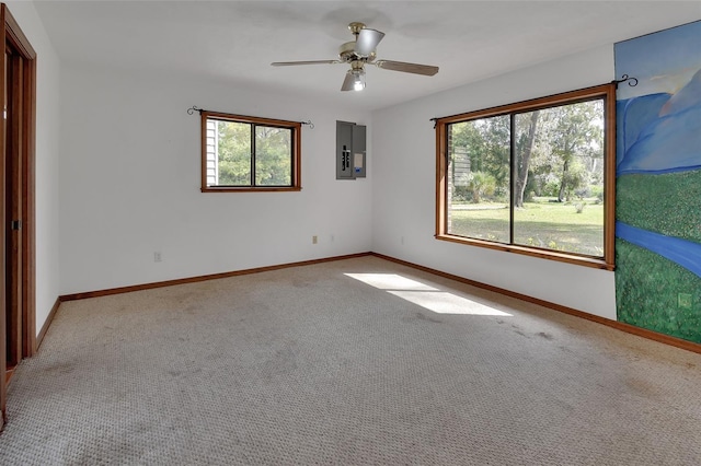 carpeted empty room featuring electric panel, baseboards, and ceiling fan