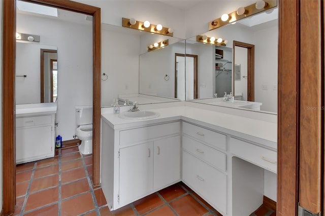 full bathroom with tile patterned flooring, double vanity, toilet, and a sink