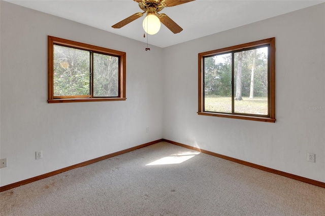 unfurnished room featuring carpet flooring, a ceiling fan, and baseboards