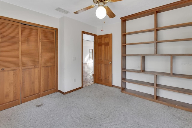 unfurnished bedroom featuring a ceiling fan, baseboards, visible vents, a closet, and light carpet