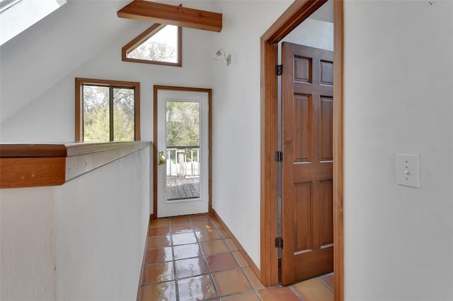 doorway to outside with lofted ceiling and baseboards