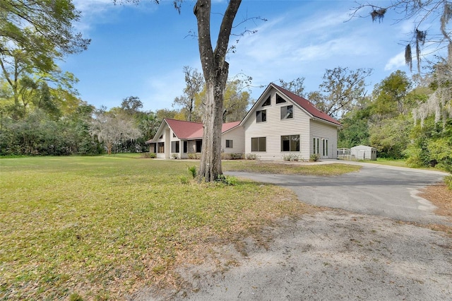 view of front of property featuring aphalt driveway and a front yard