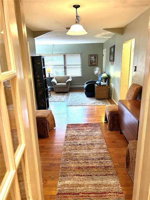 living room with baseboard heating and light hardwood / wood-style floors