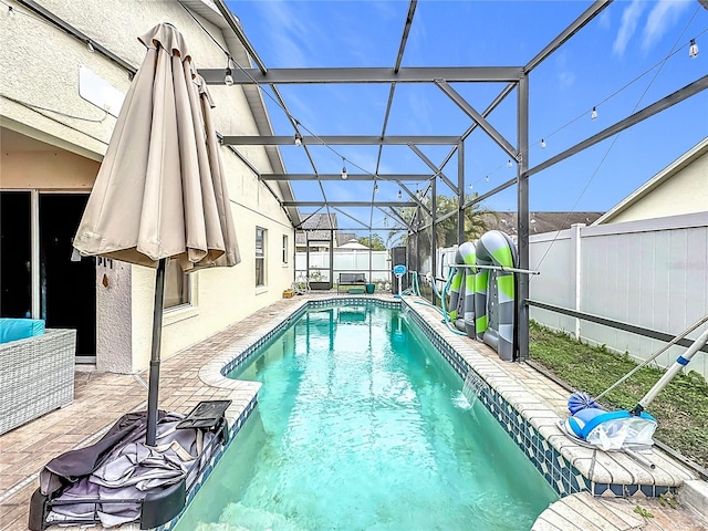 view of swimming pool featuring pool water feature, a lanai, and a patio area