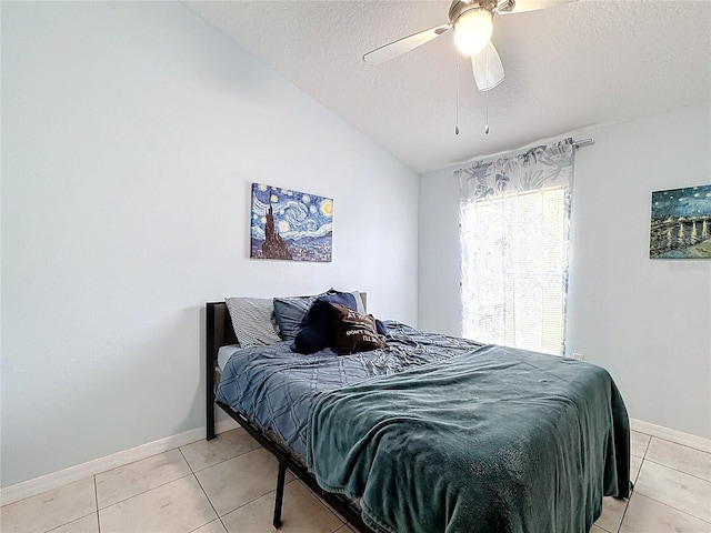 tiled bedroom with lofted ceiling, a textured ceiling, and ceiling fan