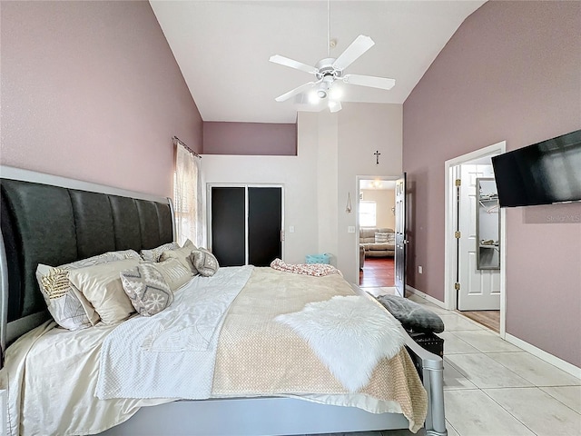 bedroom featuring vaulted ceiling, light tile patterned floors, ceiling fan, and a closet