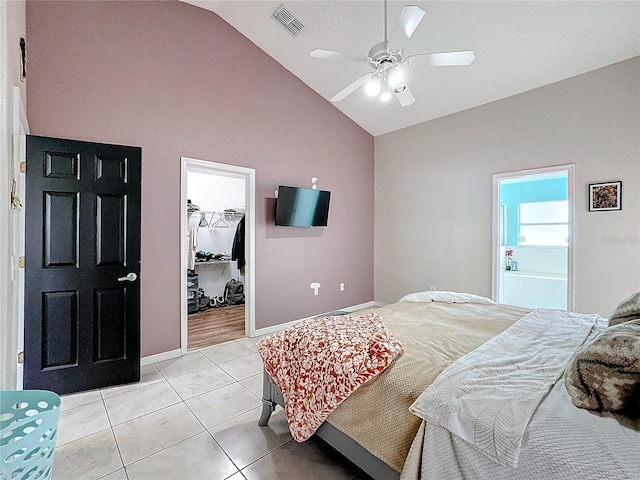 bedroom with vaulted ceiling, a spacious closet, ceiling fan, ensuite bath, and a closet