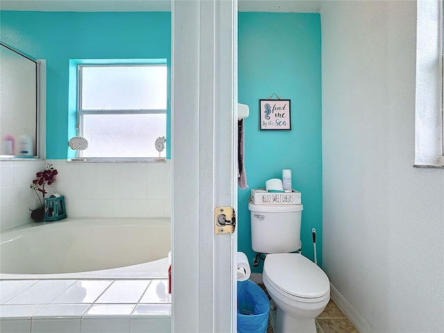 bathroom with toilet and a tub to relax in