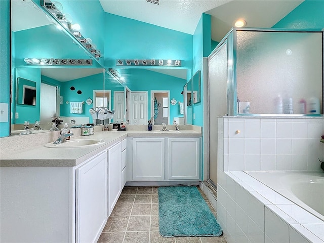 bathroom with vanity, lofted ceiling, a textured ceiling, and separate shower and tub