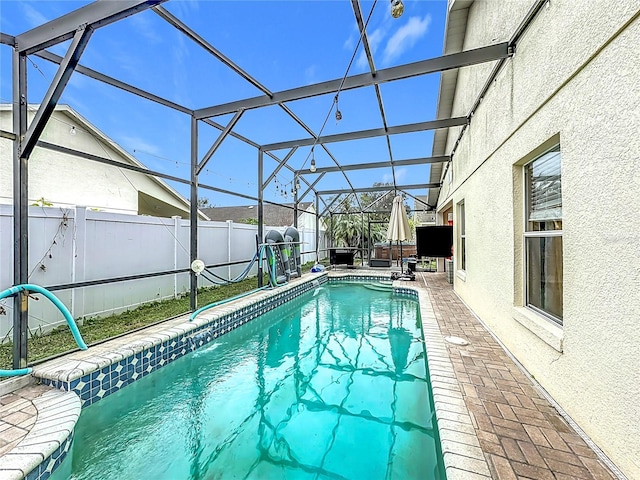 view of swimming pool featuring a patio and glass enclosure