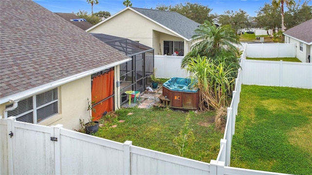 view of yard featuring a hot tub and glass enclosure