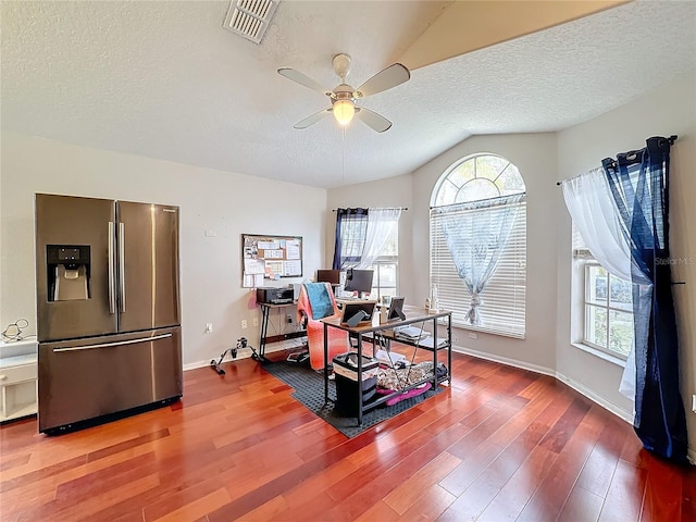 office featuring lofted ceiling, hardwood / wood-style floors, a textured ceiling, and ceiling fan