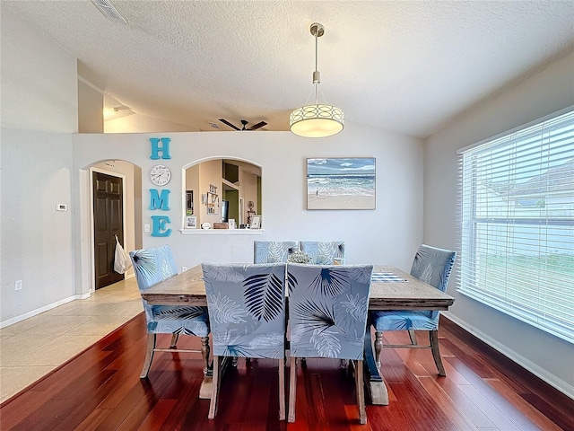 dining area featuring lofted ceiling, a healthy amount of sunlight, and hardwood / wood-style floors