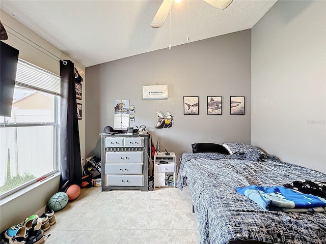 bedroom featuring lofted ceiling, a textured ceiling, and ceiling fan