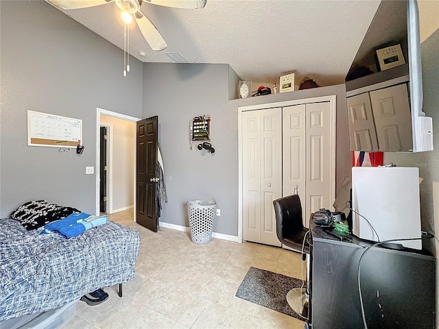 bedroom with high vaulted ceiling, a textured ceiling, ceiling fan, and a closet