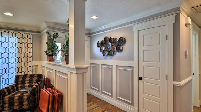 hall with ornate columns, crown molding, and wood-type flooring