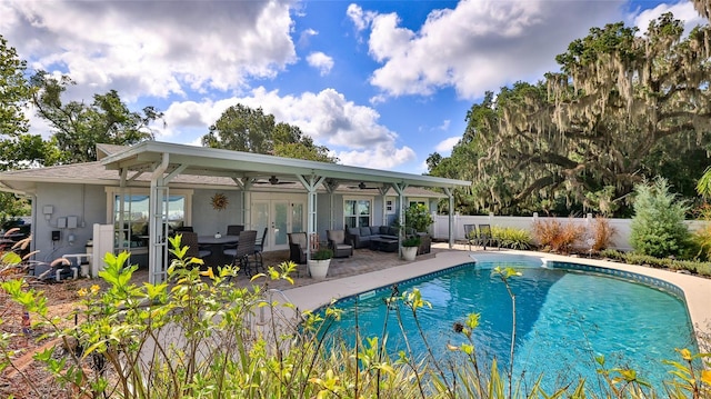 view of swimming pool featuring an outdoor living space, a patio, ceiling fan, and french doors