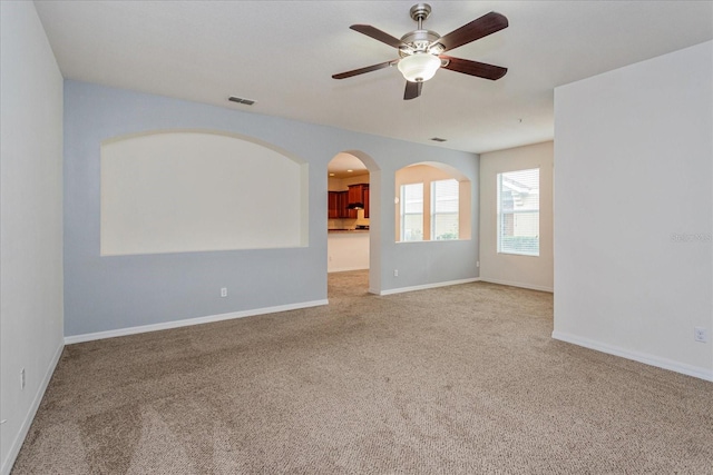 empty room featuring ceiling fan and light colored carpet