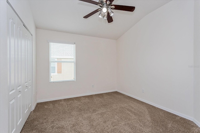 carpeted empty room with ceiling fan and vaulted ceiling