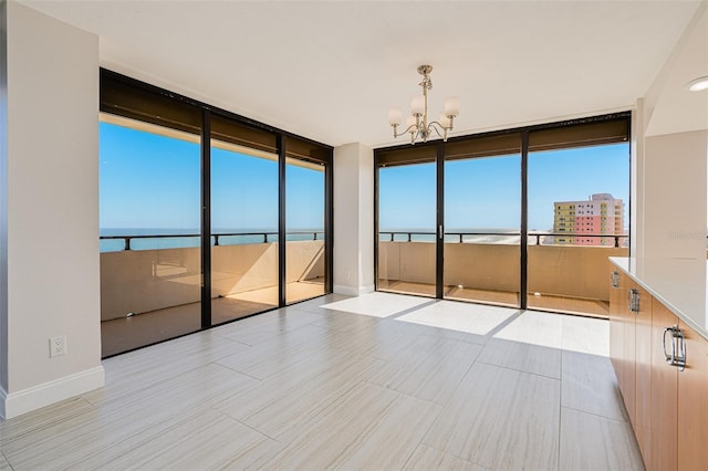 spare room featuring a notable chandelier and a water view