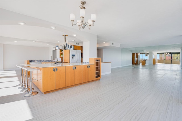 kitchen featuring hanging light fixtures, white refrigerator with ice dispenser, and a chandelier