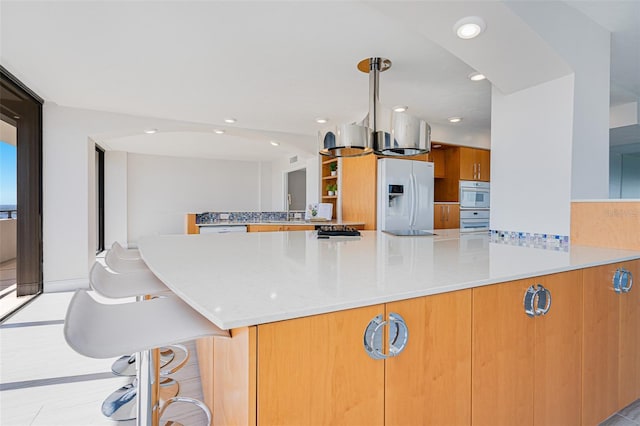 kitchen featuring light tile patterned floors, kitchen peninsula, sink, and fridge with ice dispenser