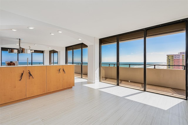 empty room featuring floor to ceiling windows and a water view