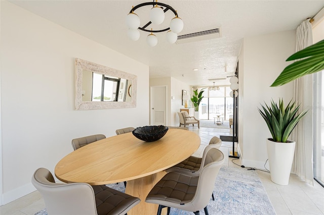 tiled dining area with an inviting chandelier and a textured ceiling