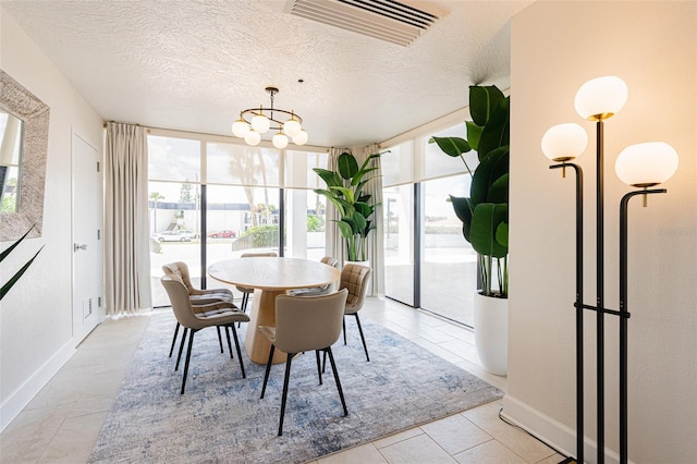 tiled dining space featuring a textured ceiling, a wall of windows, and a notable chandelier