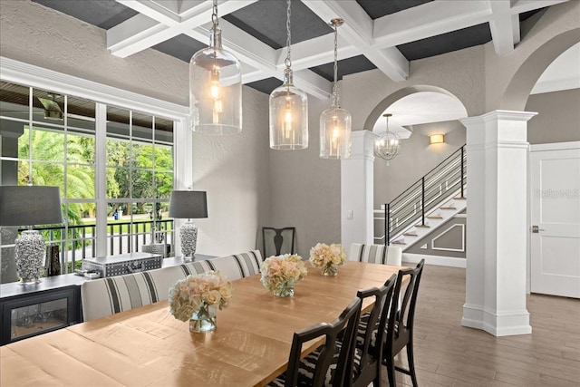 dining area featuring beam ceiling, dark hardwood / wood-style floors, coffered ceiling, and a notable chandelier