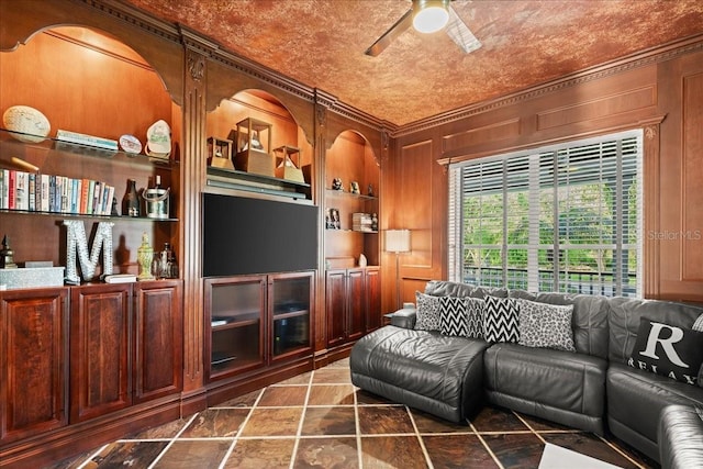 living room featuring built in shelves, crown molding, and wooden walls