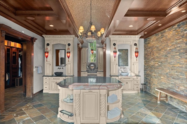 kitchen with coffered ceiling, decorative light fixtures, a chandelier, a kitchen island, and beam ceiling